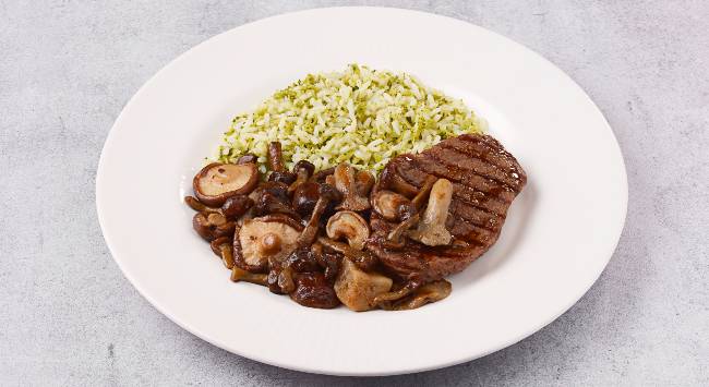 Baby beef com arroz de brócolis e mix de cogumelos servido em prato branco