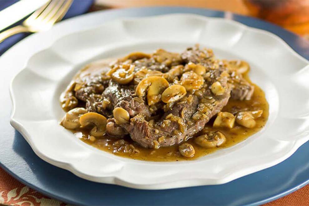 Carne com molho e champignon em prato elegante