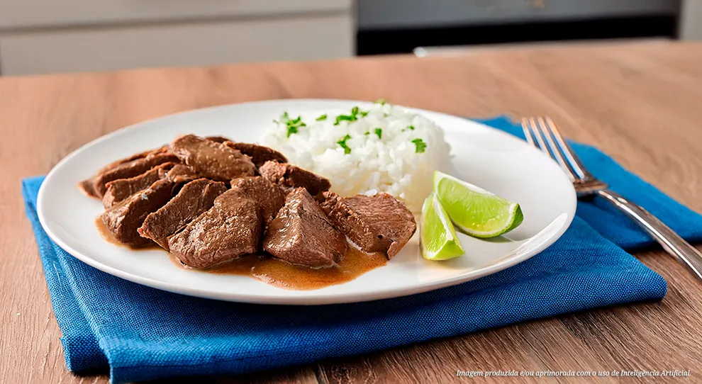 Carne de fígado macia e suculenta no prato branco, com arroz soltinho e limão fresco. Uma explosão de sabores em cada garfada! #CarneAcebolada #ArrozBranco #LimãoFresquinho