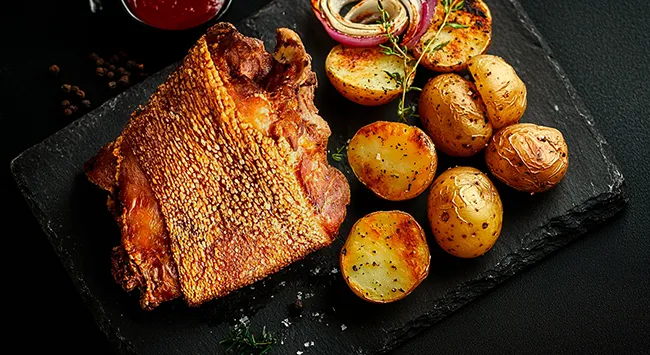 Joelho de porco rústico com batatas e cebolas