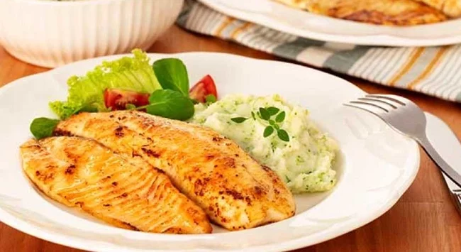 Tilápia grelhada com um purê de batata servido com brócolis e salada.