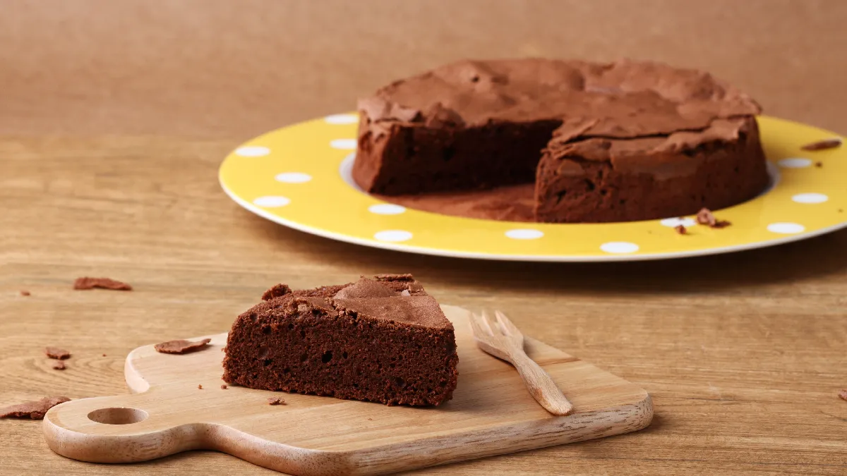 Fatia de bolo de chocolate servida em uma tábua de madeira.