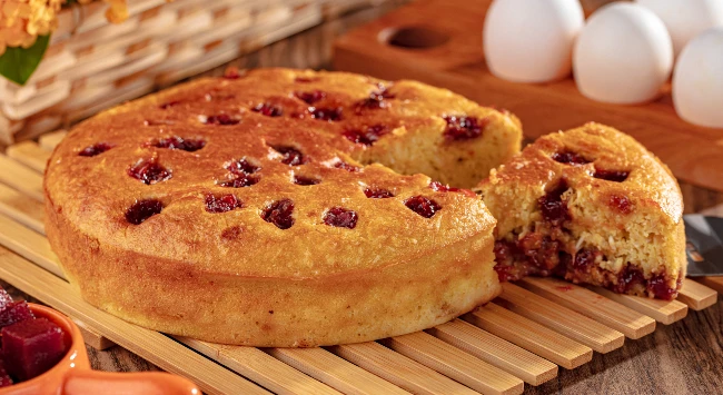 Bolo de milho recheado com cubos de goiabada.