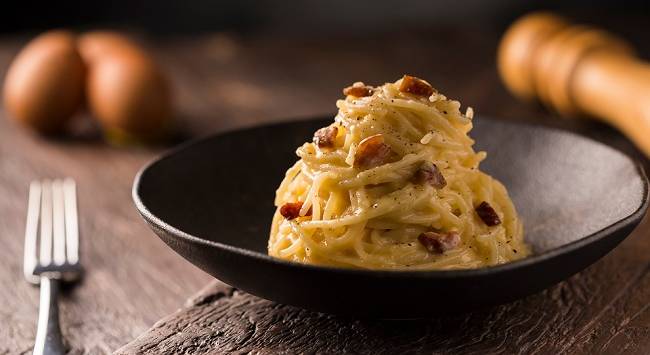 macarrão carbonara servido em tigela preta