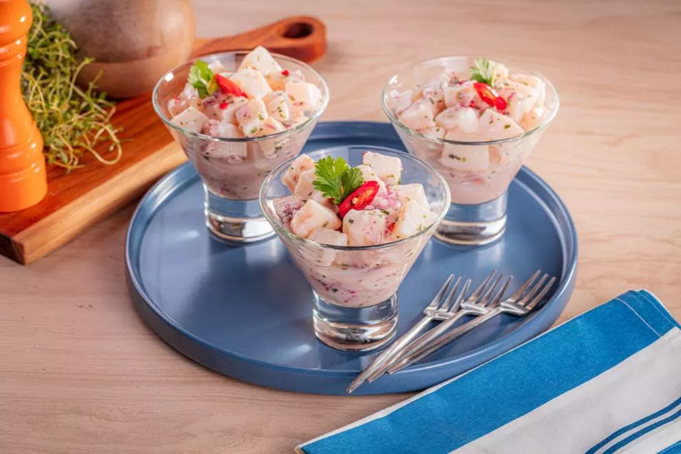 três ceviche tilápia em um recipiente transparente