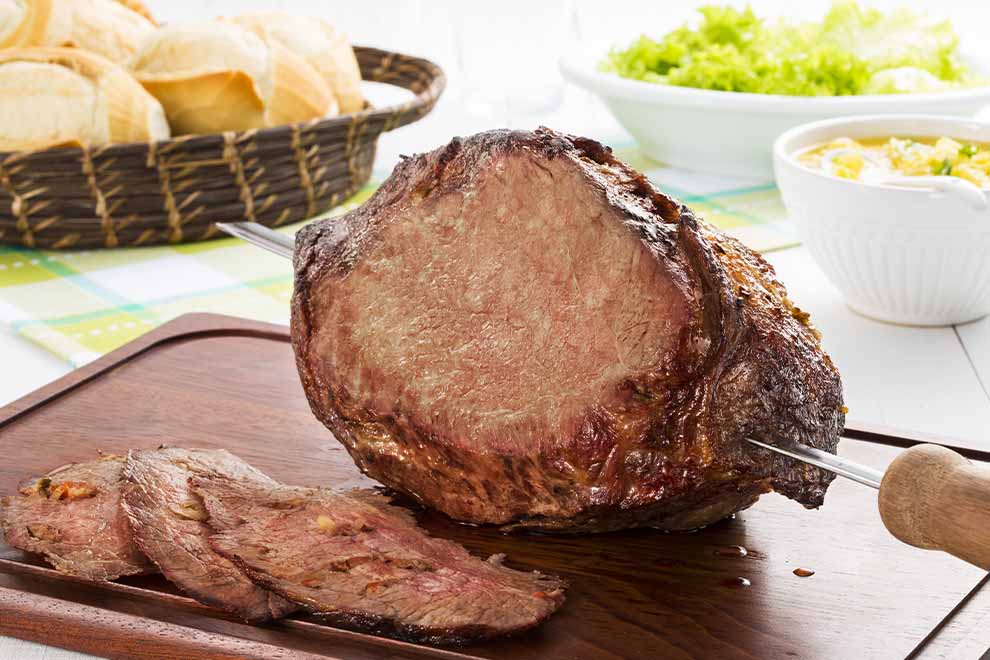 Peça de carne assada em tábua de madeira