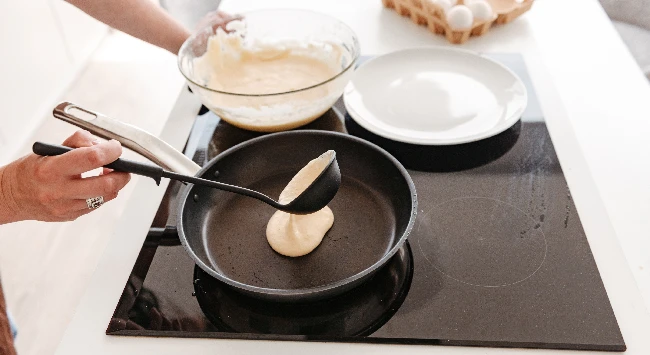 Panqueca americana sendo preparada em uma frigideira.