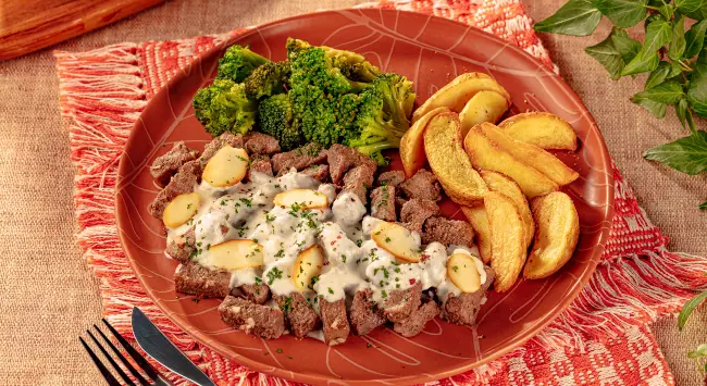 Iscas de carne com molho de parmesão e brócolis