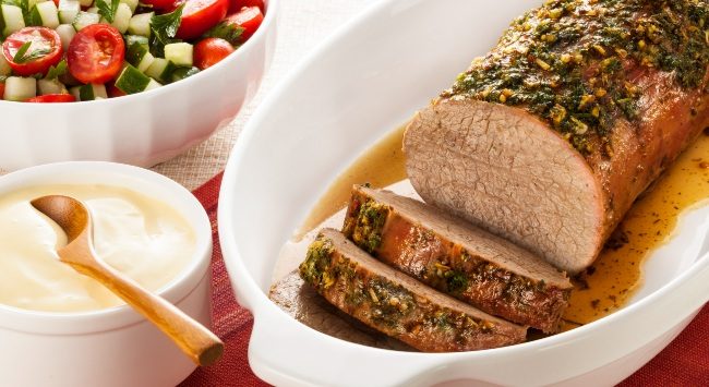 Lagarto com molho de chimichurri servido em uma travessa branca.
