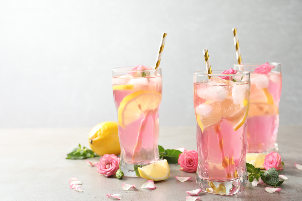 limonada rosa dentro de copo de vidro e limão siciliano