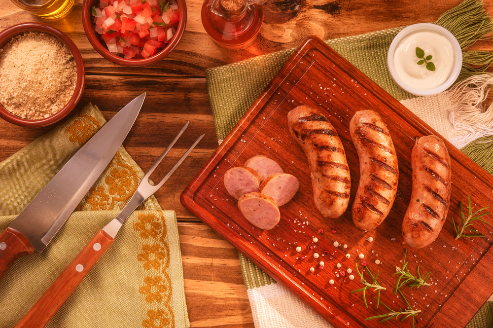 Linguiça de churrasco servida em uma tábua de carnes.