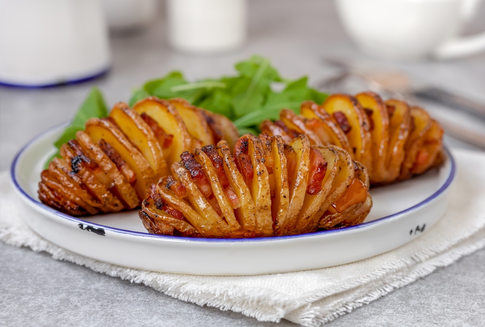 batata hasselback servida em um prato de vidro redondo