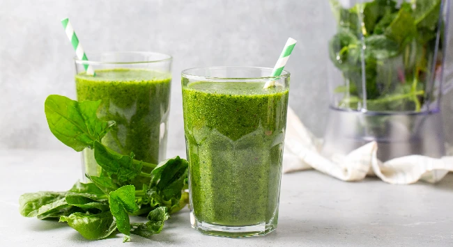 Suco verde servido em copos transparentes com canudos.