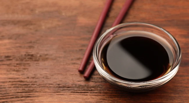 Tigela transparente com molho teriyaki.